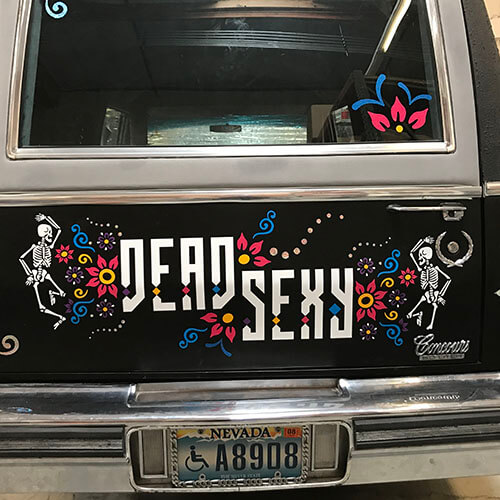 Text "Dead Sexy" on a decorative car trunk.