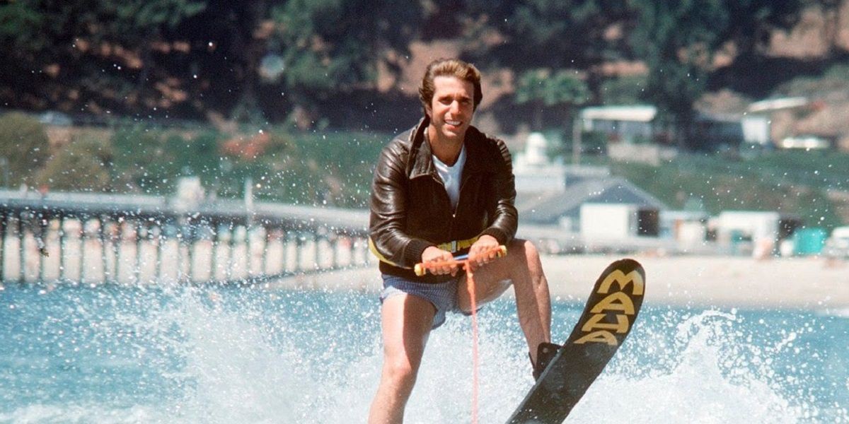 Business man water skiing in leather jacket.